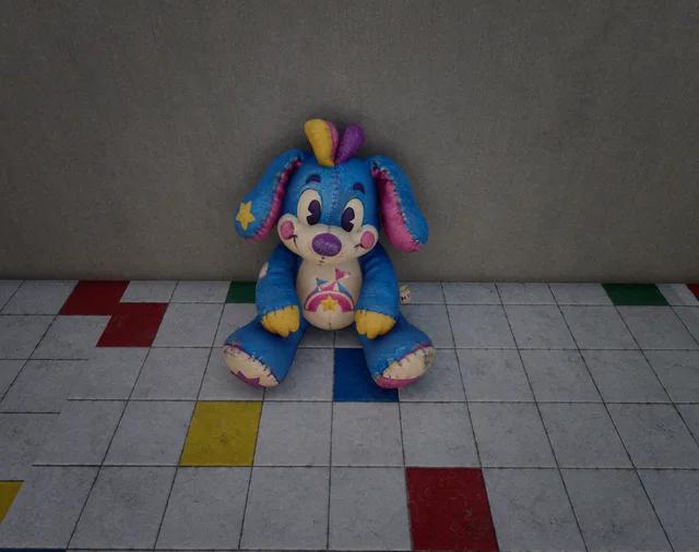 Peluche bleue aux oreilles roses posée dans une pièce du parc